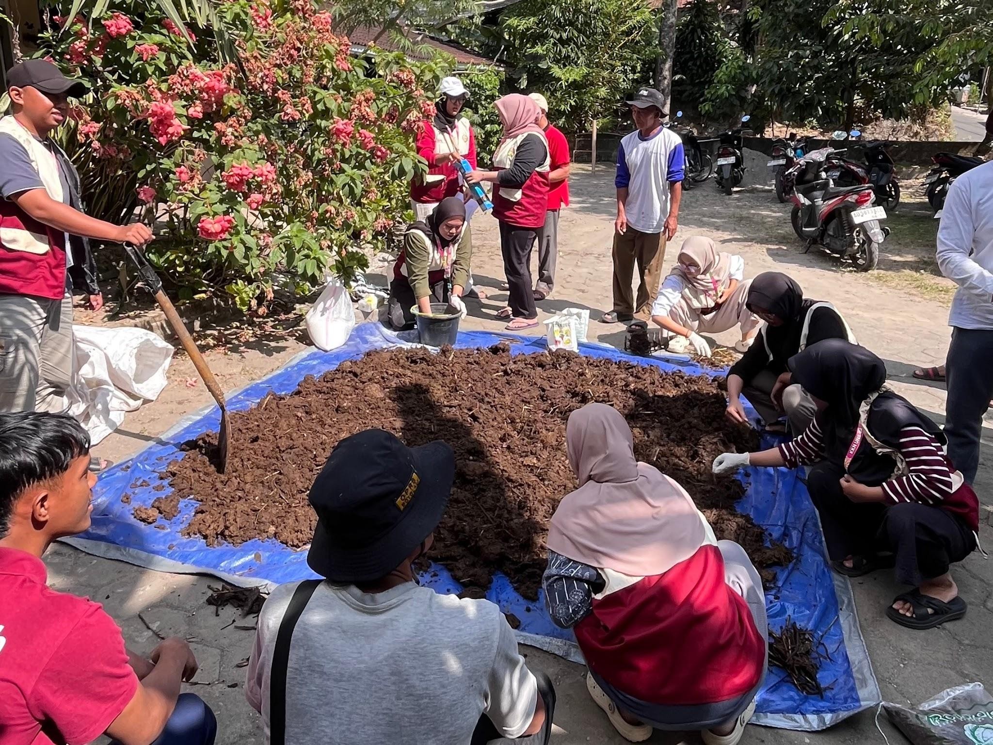 Mahasiswa KKN UNS Kelompok 44 bersama anggota Kelompok Tani Ternak Sayuk Rukun saat proses pembuatan pupuk organik padat dari kotoran sapi. (Dok. Pribadi/KKN 44 UNS)