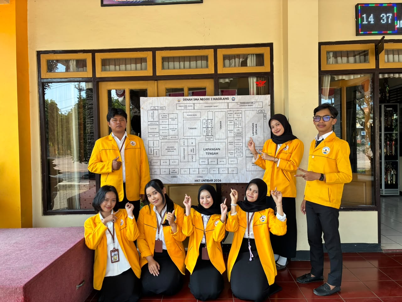 Mahasiswa Magang Kependidikan Terintegrasi (MKT) dari program studi Pendidikan Bahasa dan Sastra Indonesia (PBSI) dan Pendidikan Bahasa Inggris (PBI) Universitas Tidar melaksanakan salah satu program kerja Kuliah Kerja Nyata (KKN) berupa KIBAR (Keterangan Informasi dan Bagan Arah Ruang) di SMA Negeri 2 Magelang. (Dok. Pribadi/MKT Untidar)
