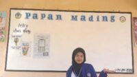 Mahasiswa PK Sheila Maura Yasmin berfoto di depan Papan mading sekolah. (Dok. Pribadi) Mahasiswa PK Sheila Maura Yasmin berfoto di depan Papan mading sekolah. (Dok. Pribadi)